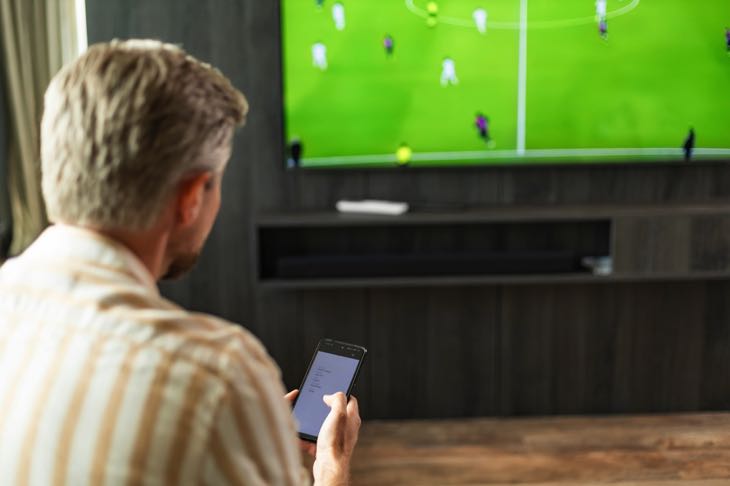 Mobile betting watching football