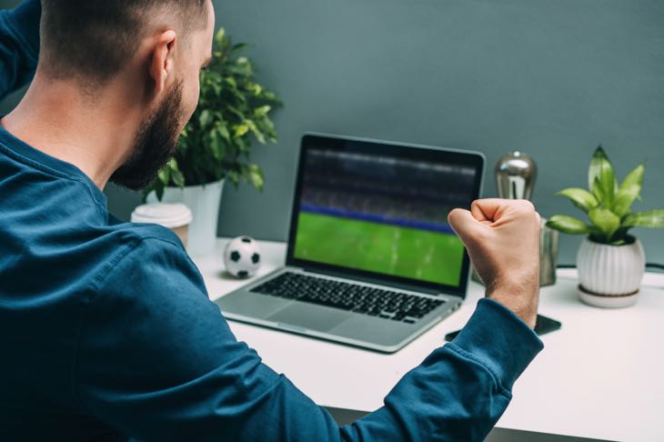 Man watching game from laptop